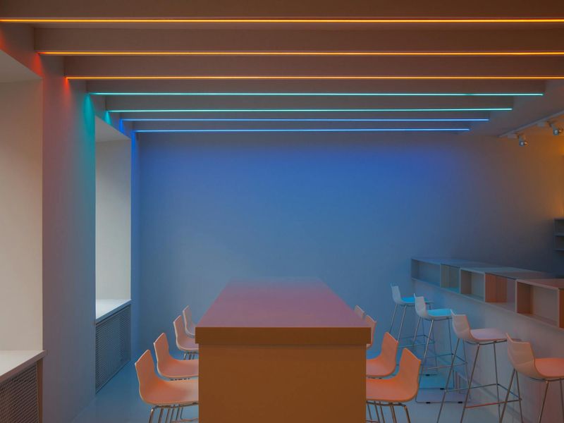 Spacious minimalist workout studio with ambient neon coral lighting